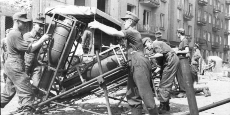 Ładowanie pocisków (32-35 cm) do wyrzutni rakietowych Wurfgerät 42 Nebelwerfer, nazywanych w Warszawie szafami lub krowami