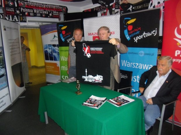 Okolicznościowa koszulka - prezentuje Prezes Jerzy Piekarzewski. z prawej Jerzy Engel, z lewej Tomasz Płochocki Koordynator Turnieju.