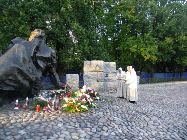 Siostry zakonne z Darmstadt modlą się na mogile prochów pochowanej tu ludności Warszawy