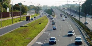 Warszawa Trasa AK w dolinie rzeki Rudawki - po prawej stronie kępa drzew (Park Olszyna), po lewej Słodowiec (widok z kładki pieszej przy ul. Żelazowskiej w kierunku południowo-zachodnim)
