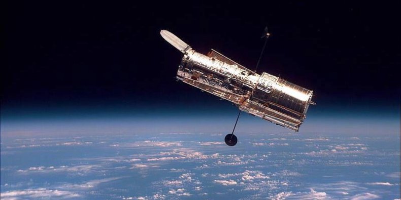Teleskop Hubble’a widziany z pokładu promu kosmicznego Discovery. Zdjęcie wykonano podczas drugiej misji serwisowej STS-82, w 1997.