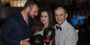Łukasz Landowski wręcza zwtcięzcy licytacji rękawice z autografami.