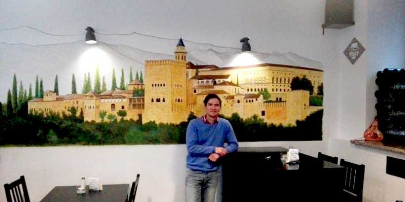 Raul Gope Govea Peralta - na tle swojego muralu "Zamek w hiszpańskiej Granadzie" w Barze Granada przy ul. Skolimowskiej 4