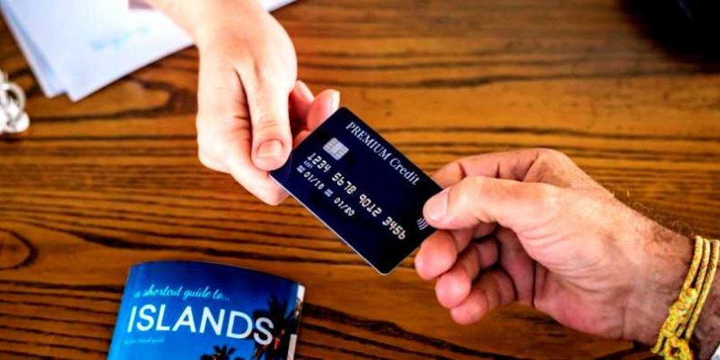 Pracownik banku wręcza kartę kredytową