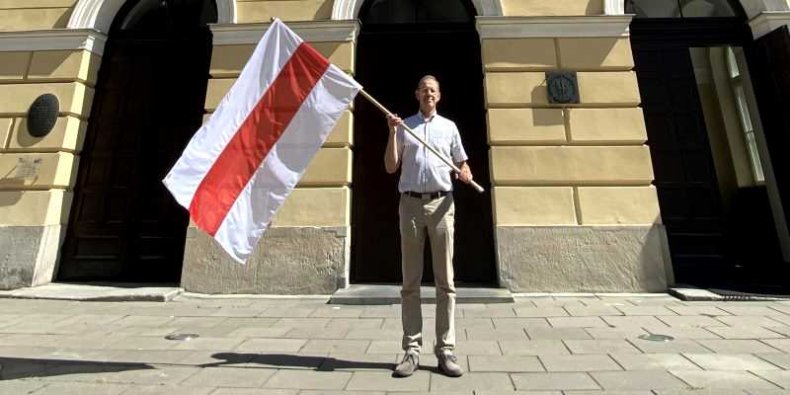 Prof. Marcin Pałys Rektor UW z flagą Białorusi na znak solidarności