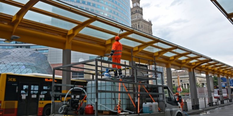 Pracownik ekipy porządkowej myje stalowo-szklaną konstrukcję wiaty nad przystankiem autobusowym przy Dworcu Centralnym Fot. Zarząd Oczyszczania Miasta