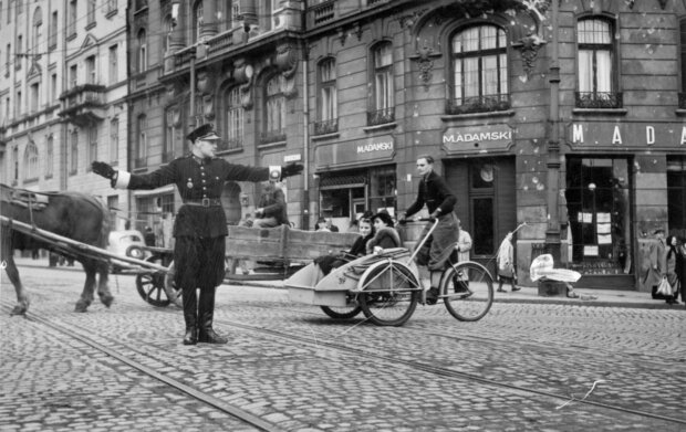 Polski policjant kieruje ruchem na skrzyżowaniu ul. Nowy Świat i Książęcej. Widoczny zakład pogrzebowy Mieczysława Adamskiego i riksza. Październik 1940 r .