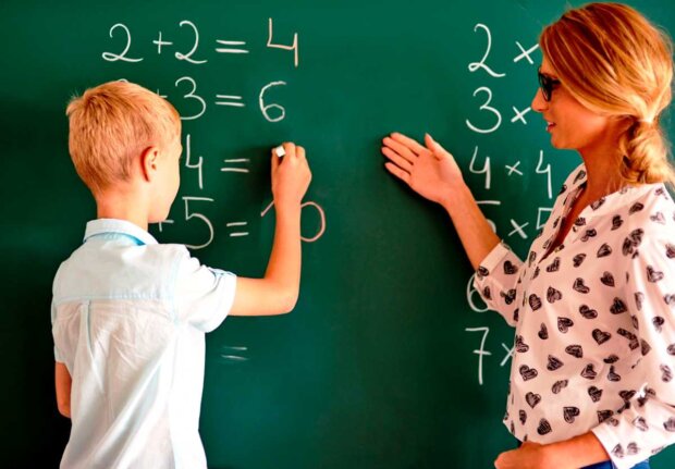 Uczeń przy tablicy z nauczycielką matematyki