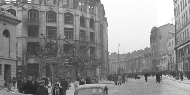 Miejsce akcji pod Arsenałem. ok. 1940 r. Ulica Długa, widok w kierunku wschodnim. Po lewej stronie Arsenał i wypalony gmach Pasażu Simonsa (w marcu 1943 już częściowo rozebrany). Fot. Rutkowski, Heinz / CC-BY-SA