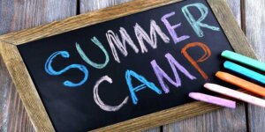 Letnie półkolonie językowe - obrazek tablica z napisem Summer Camp