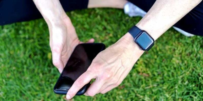 Dłonie trzymają telefon, na ręku zegarek. WatchOS - przeglad najnowszych funkcji. Źr. Materiał prasowy