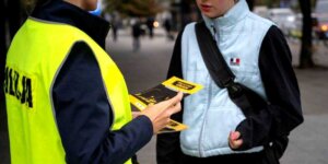 Warszawski Tydzień Bezpieczeństwa - osoba w policyjnej kamizelce odblaskowej wręcza ulotkę. Fot. Rafał Motyl UM Warszawa