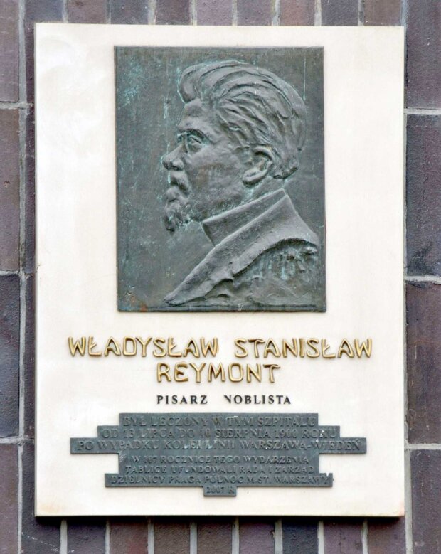 Tablica upamiętniająca Władysława Reymonta przy wejściu do Szpitala Przemienienia Pańskiego. Napis: Władysław Stanisław Reymont. Pisarz noblista. Był leczony w tym szpitalu od 13 lipca do 10 sierpnia 1900 roku po wypadku kolei linii Warszawa-Wiedeń. W rocznicę tego wydarzenia. Tablicę ufundowali Rada i Zarząd Dzielnicy Praga Północ m.st. Warszawy. 2007 r. Fot. Adrian Grycuk źr. Wikimedia