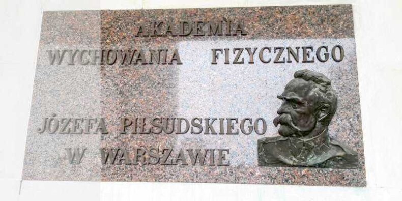 Tablica przed wejściem do budynku głównego AWF Warszawa z płaskorzeźbą Józefa Piłsudskiego dłuta Feliksa Robaka – Robakowskiego z 1928 roku. Fot. Kamil Potrzuski